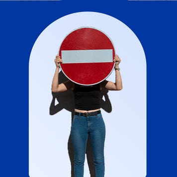 Man blocking face by holding a stop sign in front of himself