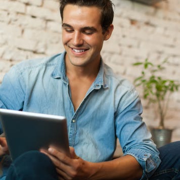 A man researches on a tablet.