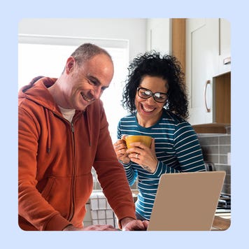Man and women looking at a computer and smiling